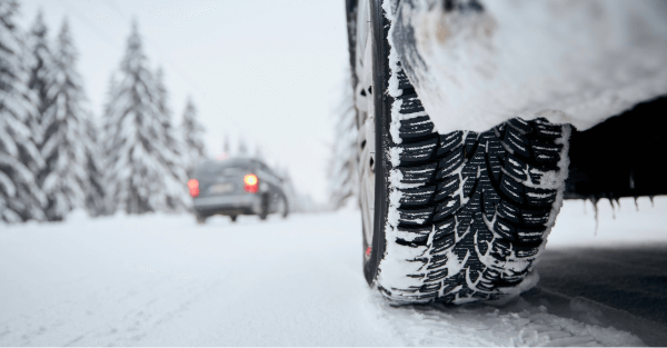 Closeup of car tire driving on snow